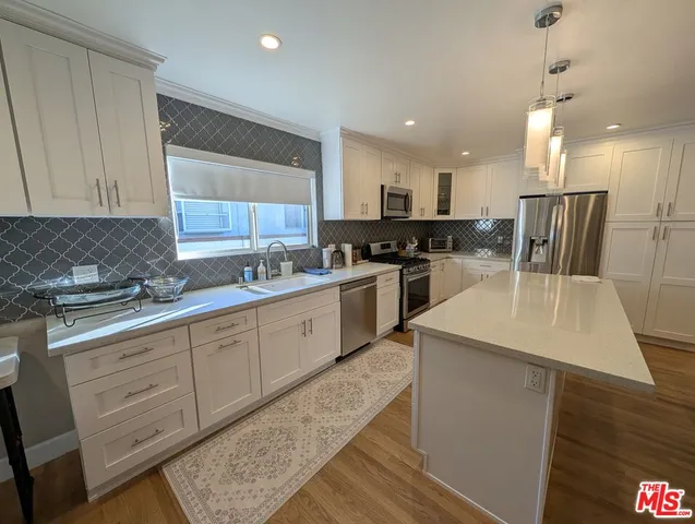 a kitchen with a sink a counter top space and appliances