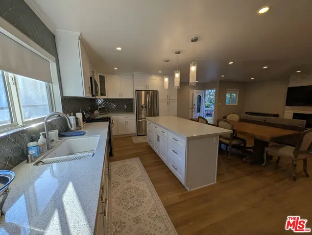 a large white kitchen with a large counter top appliances and a couch