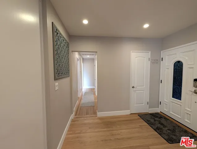 a view of a hallway with closet and wooden floor