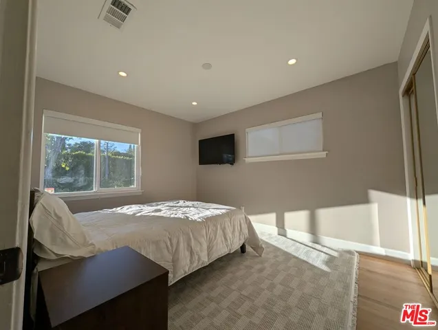 a bedroom with a bed and glass window