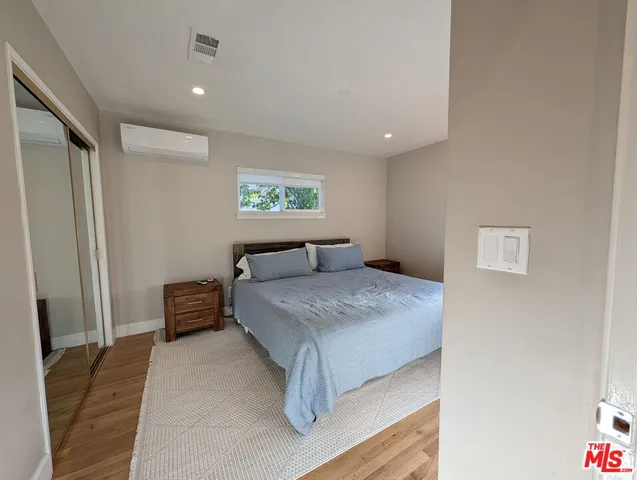 a bedroom with a bed and a painting on the wall