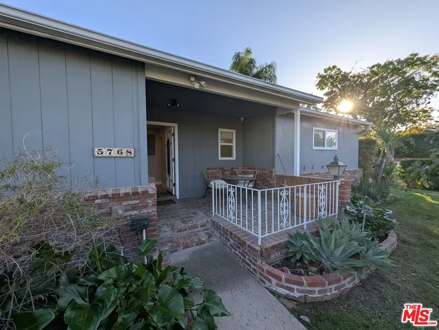 a view of a house with a yard and potted plants