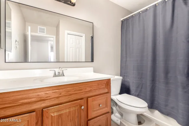 a bathroom with a granite countertop sink mirror vanity and toilet
