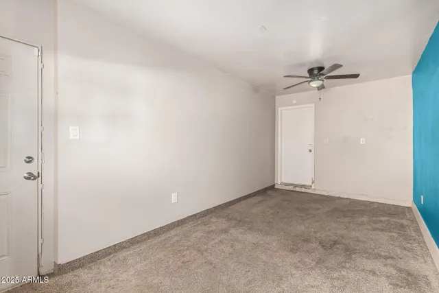 an empty room with a ceiling fan and a window