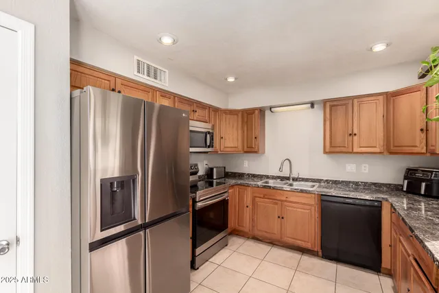 a kitchen with stainless steel appliances granite countertop a refrigerator sink and cabinets