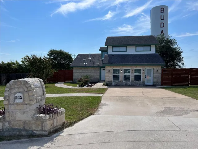 a front view of a house with a garden and yard