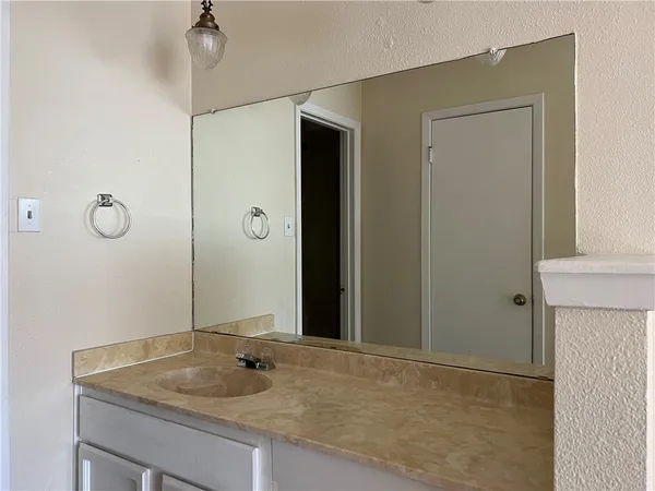 a bathroom with a granite countertop sink and a mirror