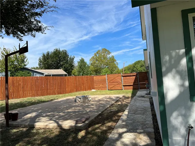a view of a backyard with wooden fence