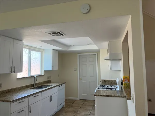 a kitchen with stainless steel appliances granite countertop a sink stove and cabinets