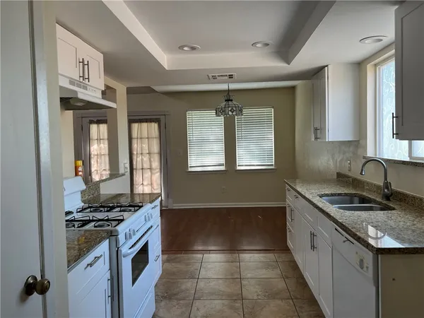 a kitchen with granite countertop a sink and a stove