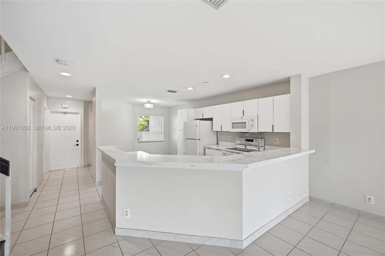 6215 Old Court Road, Unit 505 Boca Raton, FL 33433 - Photo 6 of 36 a view of a kitchen with kitchen island a sink stainless steel appliances and cabinets