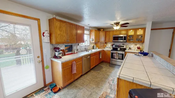 a kitchen with stainless steel appliances kitchen island granite countertop a stove and a sink