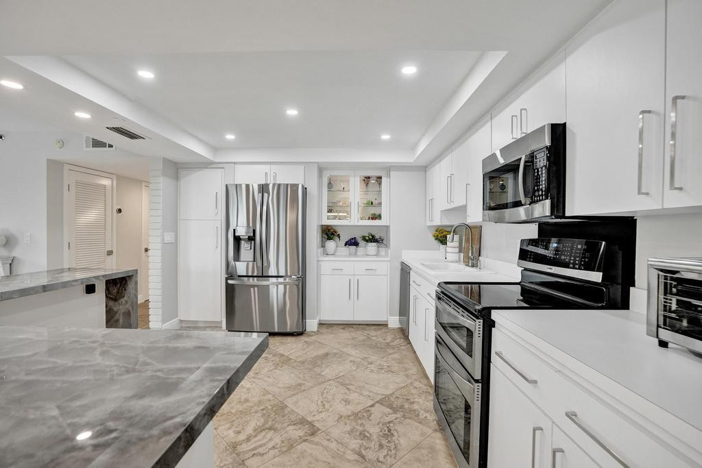 501 North Riverside Drive, Unit 203 Pompano Beach, FL 33062 - Photo 14 of 63 a kitchen with stove cabinets and refrigerator
