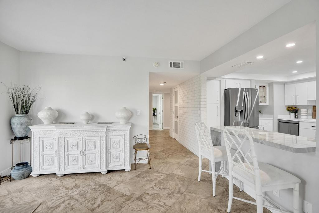 501 North Riverside Drive, Unit 203 Pompano Beach, FL 33062 - Photo 26 of 63 a large white kitchen with white cabinets and stainless steel appliances