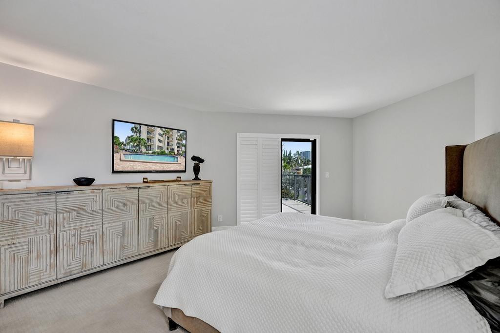 501 North Riverside Drive, Unit 203 Pompano Beach, FL 33062 - Photo 29 of 63 a bedroom with a bed and a large mirror