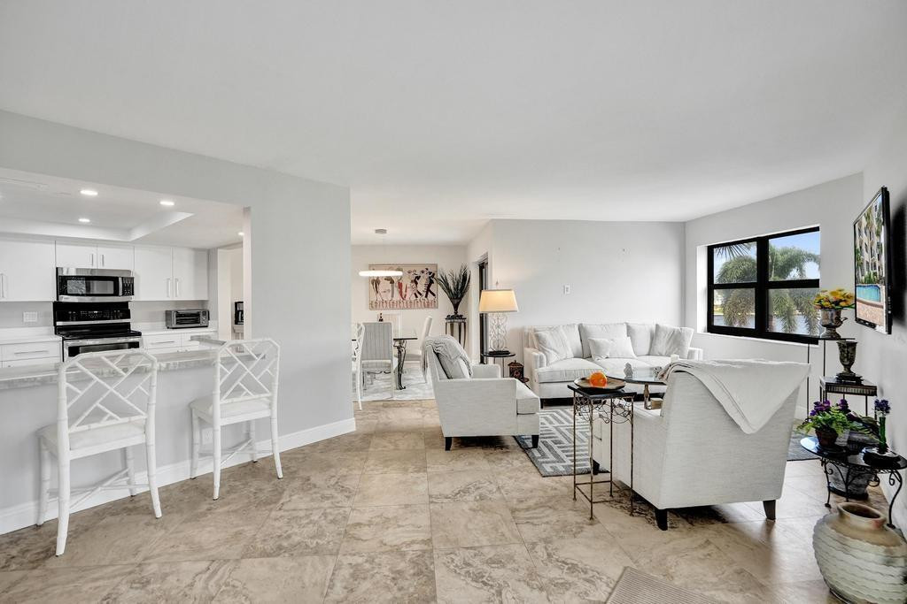 501 North Riverside Drive, Unit 203 Pompano Beach, FL 33062 - Photo 8 of 63 a living room with furniture and a flat screen tv