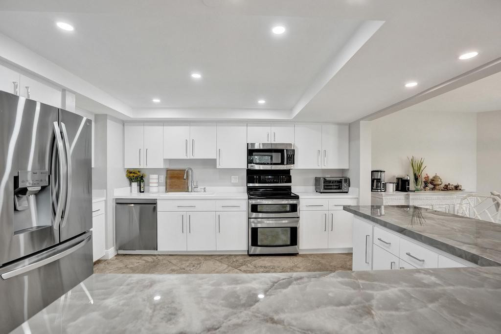 501 North Riverside Drive, Unit 203 Pompano Beach, FL 33062 - Photo 10 of 63 a kitchen with refrigerator and cabinets
