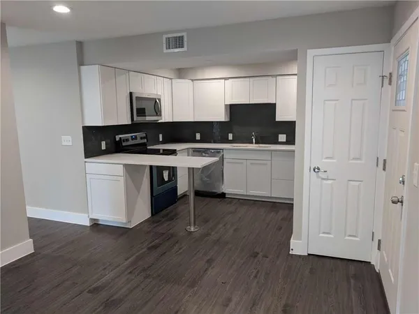 a kitchen with stainless steel appliances a white cabinets and sink