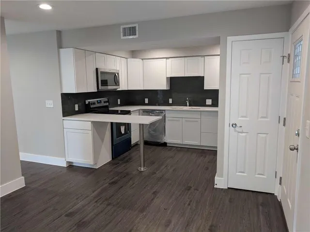 a kitchen with stainless steel appliances a white cabinets and sink