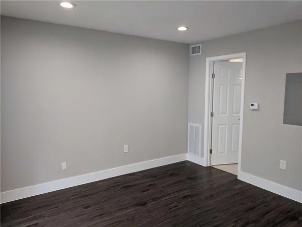 a view of an empty room with wooden floor