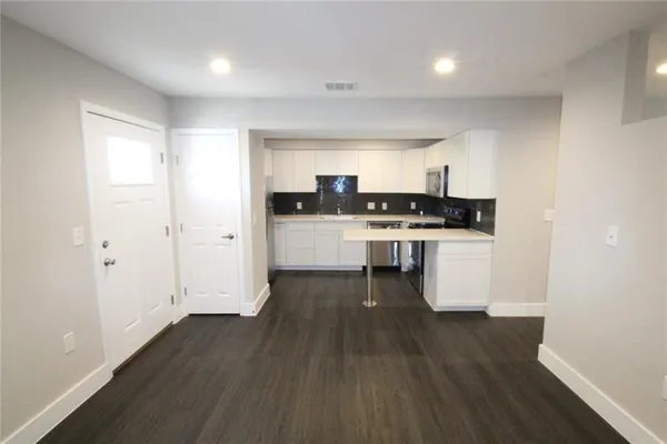 a kitchen with wooden floors and white appliances
