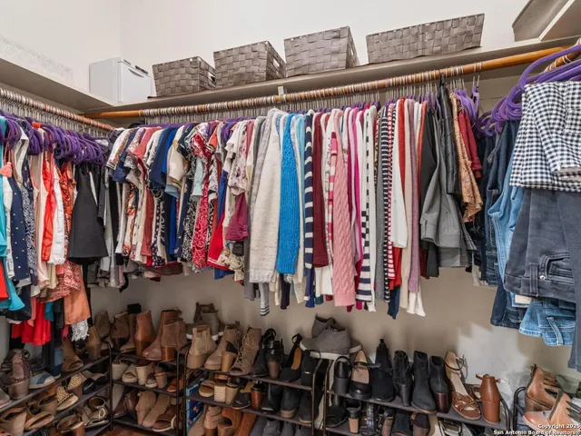 a view of walk in closet with clothes and shoes