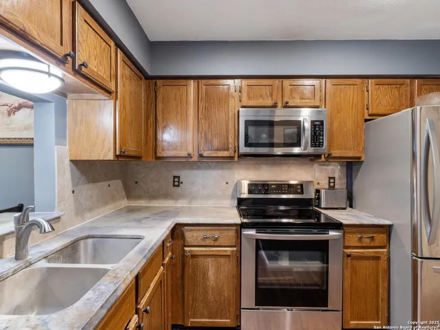 a kitchen with stainless steel appliances granite countertop a sink and a microwave