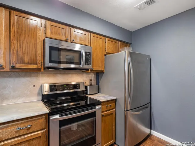 a kitchen with stainless steel appliances a refrigerator stove and microwave