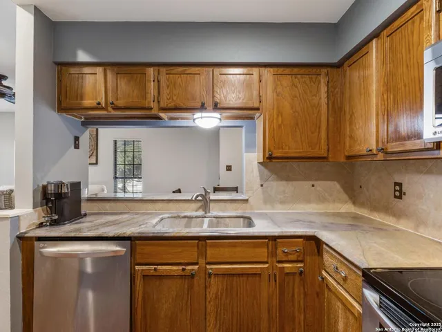 a kitchen with stainless steel appliances granite countertop a sink stove and cabinets