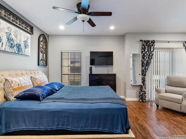 a bedroom with a bed flat screen tv and couches