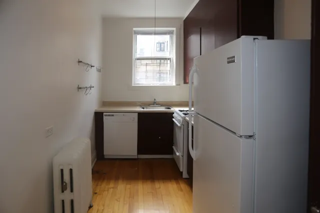 a utility room with wooden floor washer and dryer