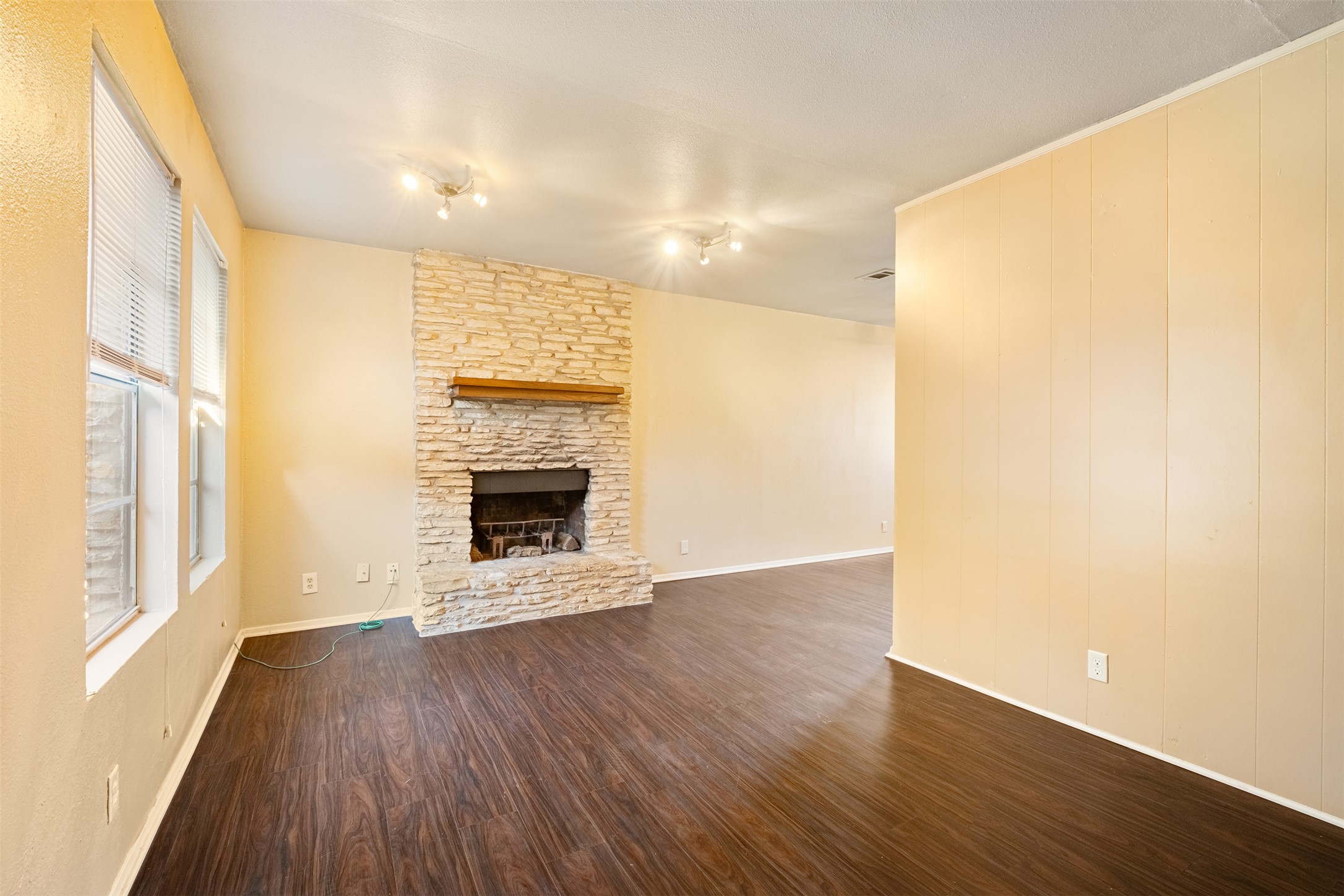 5801 Libyan Drive, Unit B Austin, TX 78745 - Photo 3 of 20 Unfurnished living room featuring dark wood-type flooring and a fireplace