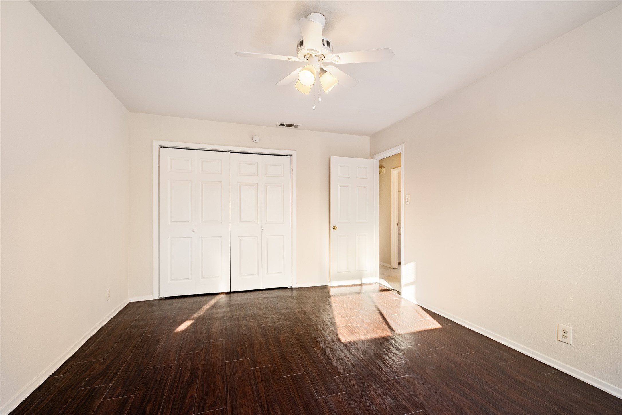 5801 Libyan Drive, Unit B Austin, TX 78745 - Photo 5 of 20 Unfurnished bedroom featuring dark wood-type flooring, a closet, and ceiling fan