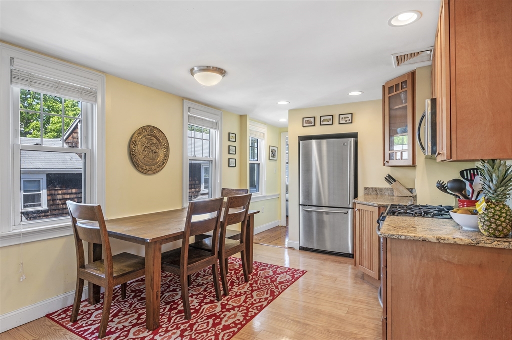 11 Williams Street, Unit 2 Salem, MA 01970 - Photo 7 of 33 a kitchen with stainless steel appliances granite countertop a dining table chairs and a refrigerator