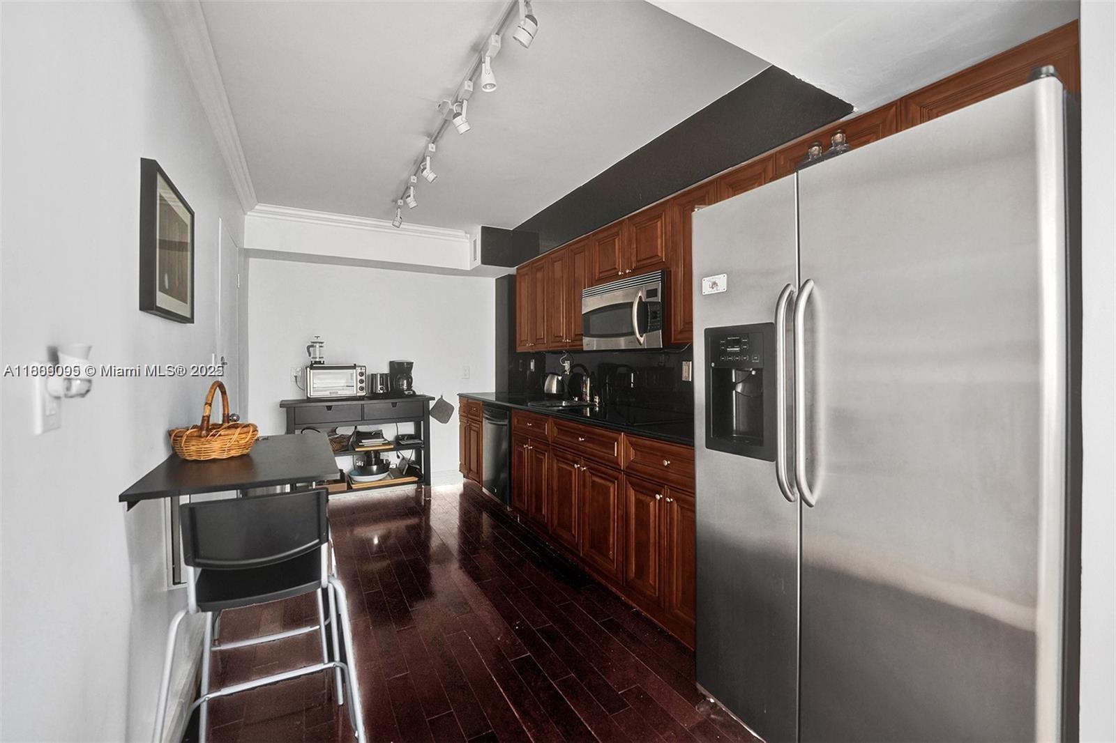 9195 Collins Avenue, Unit 304 Surfside, FL 33154 - Photo 11 of 32 a kitchen with stainless steel appliances kitchen island granite countertop a refrigerator a stove and a sink with granite countertops
