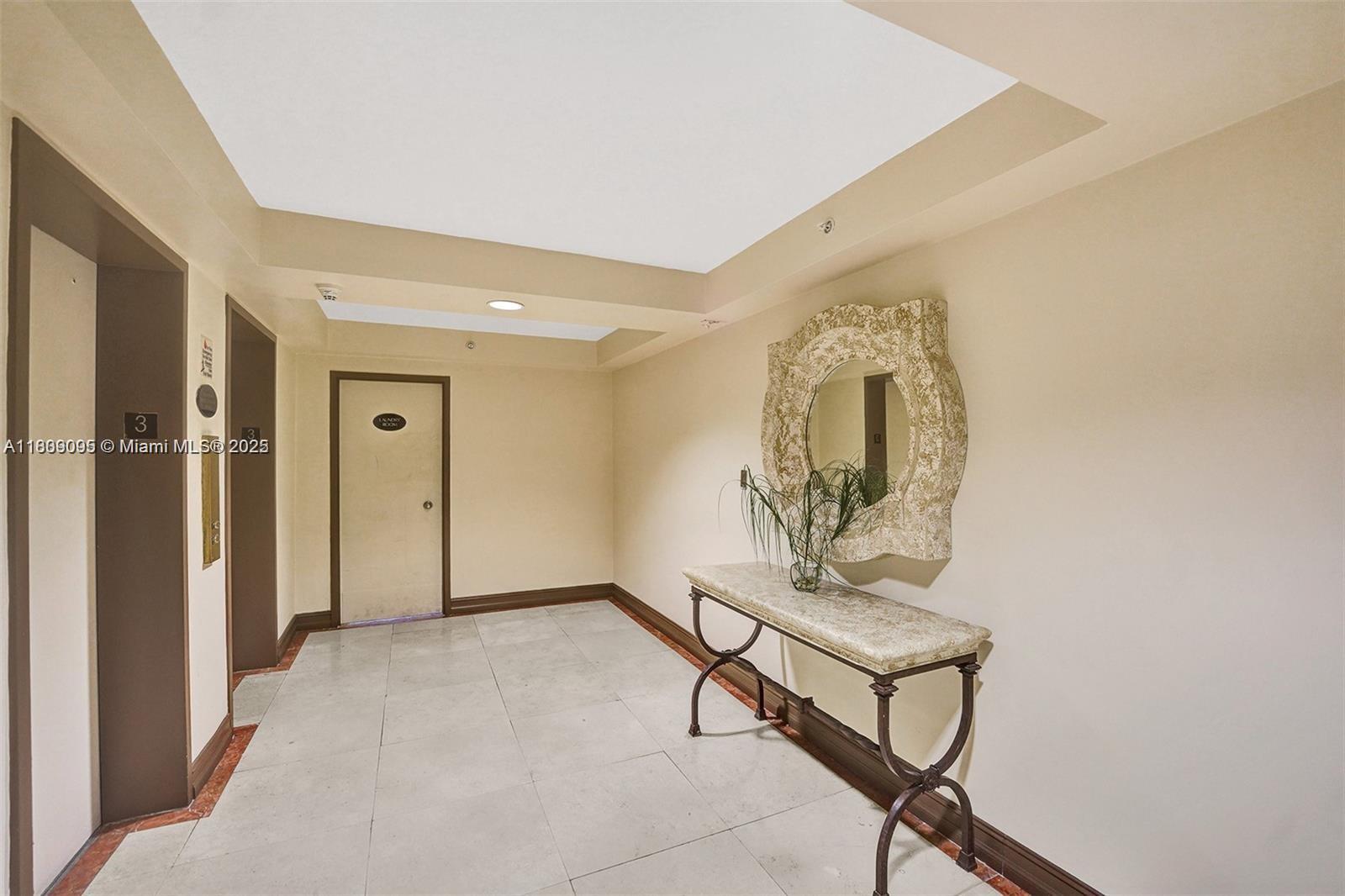 9195 Collins Avenue, Unit 304 Surfside, FL 33154 - Photo 22 of 32 a view of a hallway with paintings on the wall