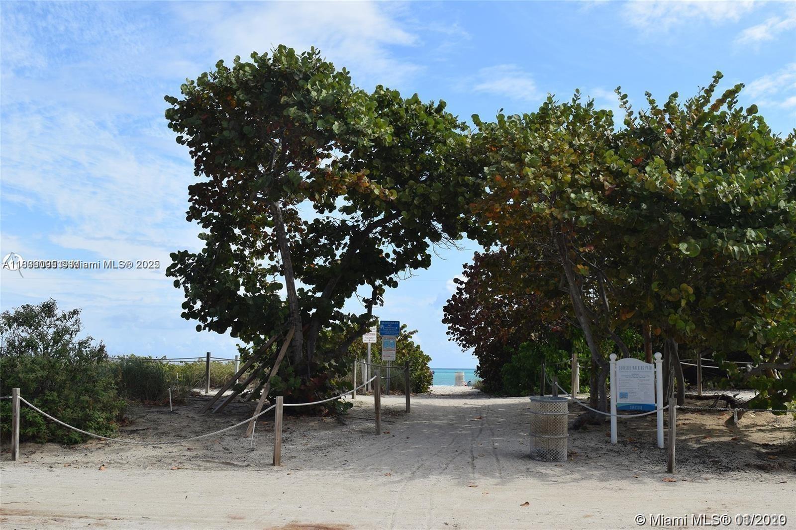 9195 Collins Avenue, Unit 304 Surfside, FL 33154 - Photo 27 of 32 a backyard of a house with table and chairs