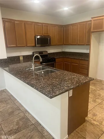 a kitchen with granite countertop a sink and a stove top oven
