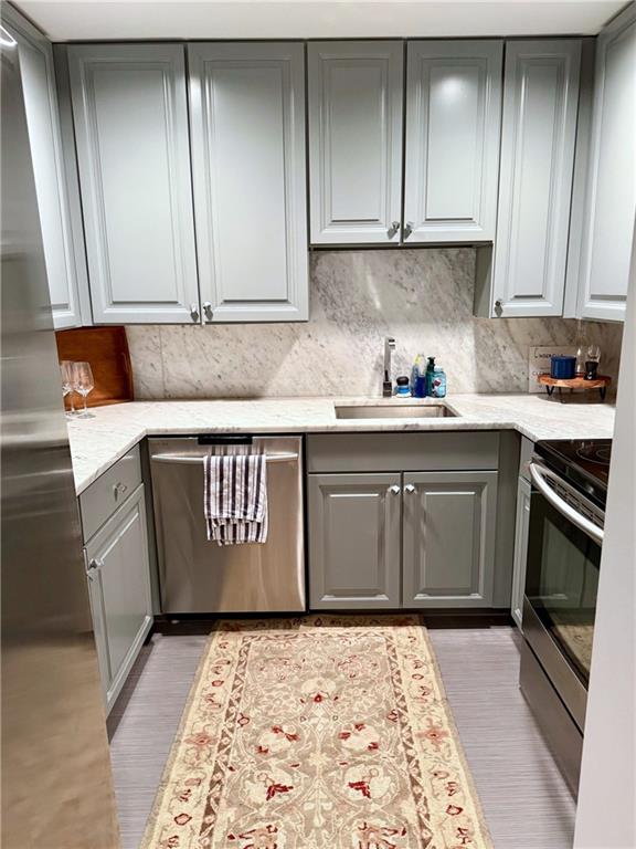 195 14th Street Northeast, Unit 312 Atlanta, GA 30309 - Photo 17 of 33 a kitchen with granite countertop stainless steel appliances a stove a sink and cabinets
