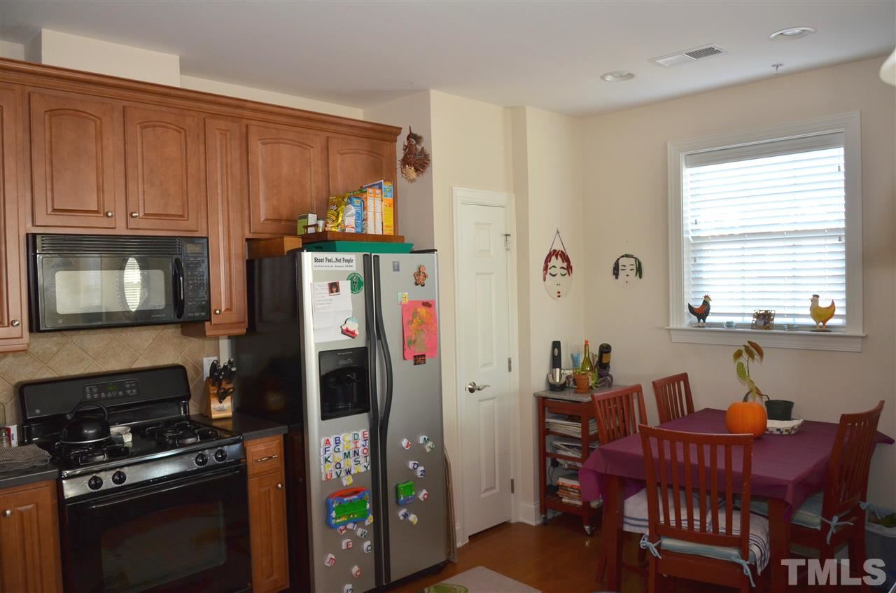 10421 Rosegate Court, Unit 203 Raleigh, NC 27617 - Photo 6 of 8 a kitchen with stainless steel appliances granite countertop a refrigerator and a stove top oven