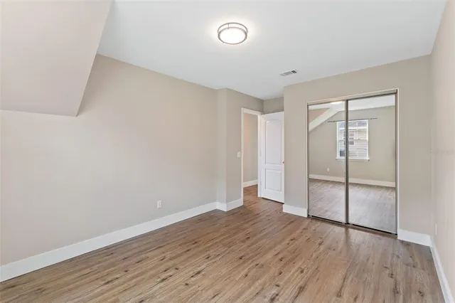 a view of an empty room with wooden floor