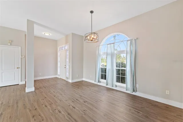 a view of a room with chandelier fan and wooden floor