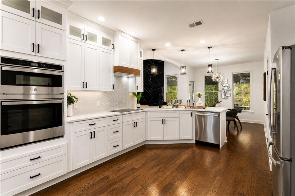 1217 Cabin Bridge Road Bethlehem, GA 30620 - Photo 20 of 43 a kitchen with granite countertop cabinets stainless steel appliances and wooden floor