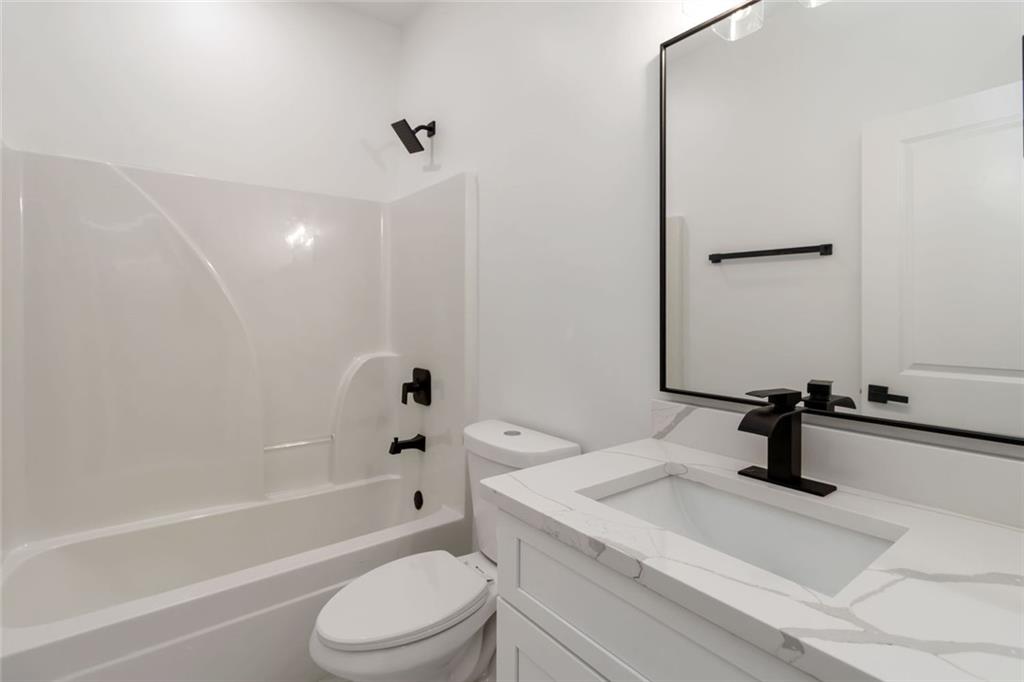 1217 Cabin Bridge Road Bethlehem, GA 30620 - Photo 42 of 43 a bathroom with a sink a toilet a mirror and shower