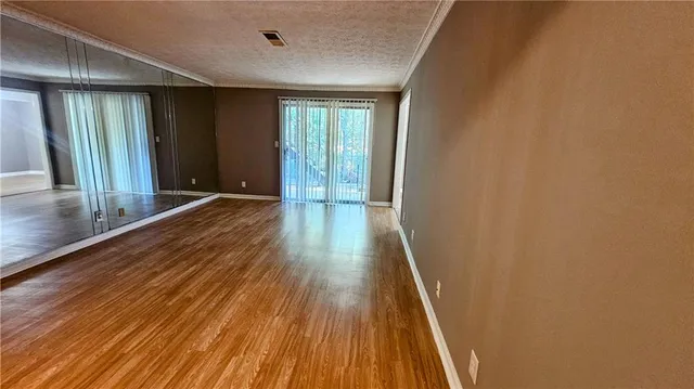 an empty room with a window and a ceiling fan