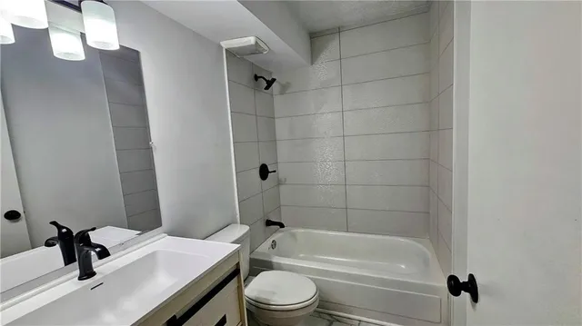 an empty room with wooden floor chandelier fan and windows