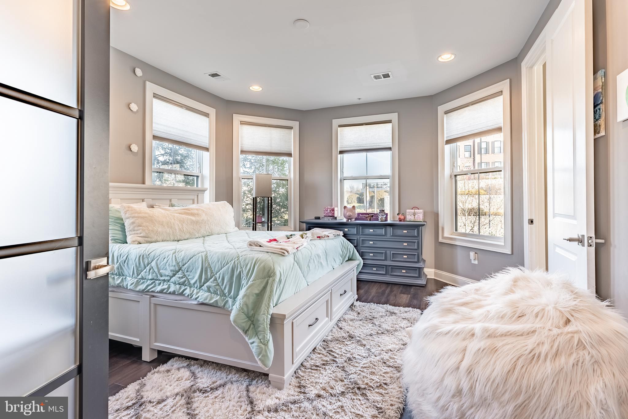 500 Riversail Lane, Unit 438 Oxon Hill, MD 20745 - Photo 8 of 54 a bedroom with a large bed and wooden floor