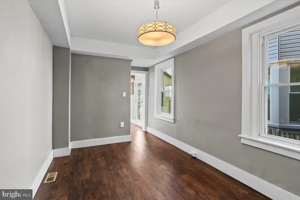 a view of a hallway with wooden floor and a window