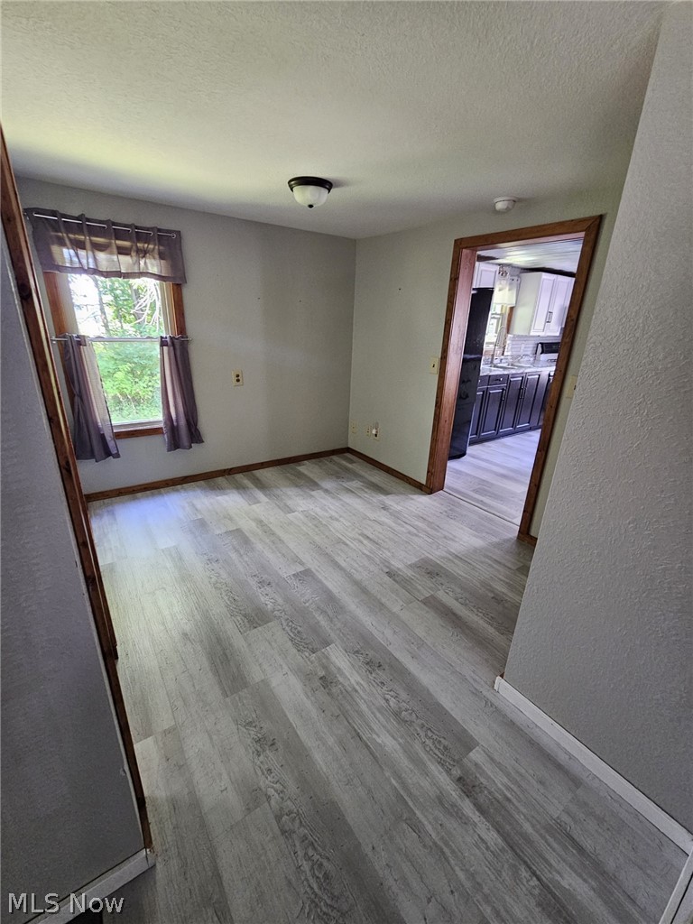5847 Struthers Road Lowellville, OH 44436 - Photo 10 of 26 Empty room with a textured ceiling and wood-type flooring