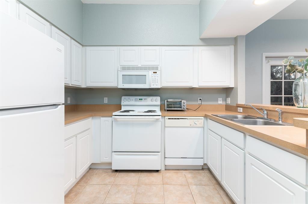 4850 Southwest 91 Terrace, Unit 301 Gainesville, FL 32608 - Photo 7 of 24 a kitchen with granite countertop white cabinets and white appliances